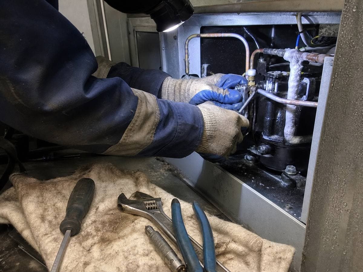 Cold Rescue technician repairing a commercial refrigeration compressor