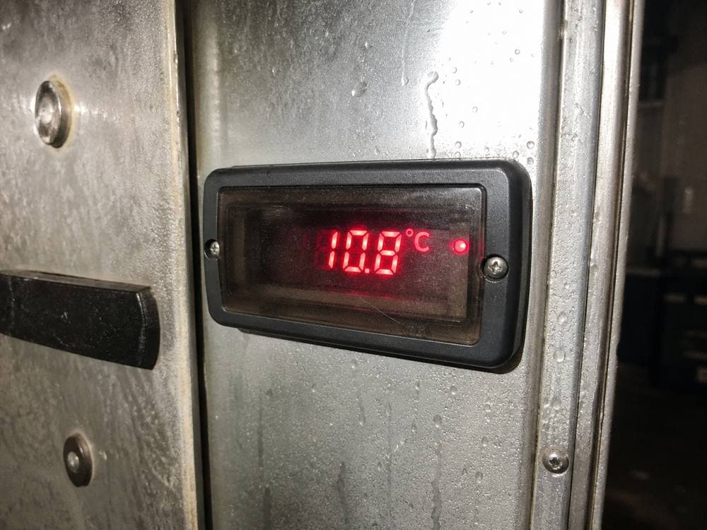 Walk-in cooler thermostat showing a temperature warning at a cold chain warehouse